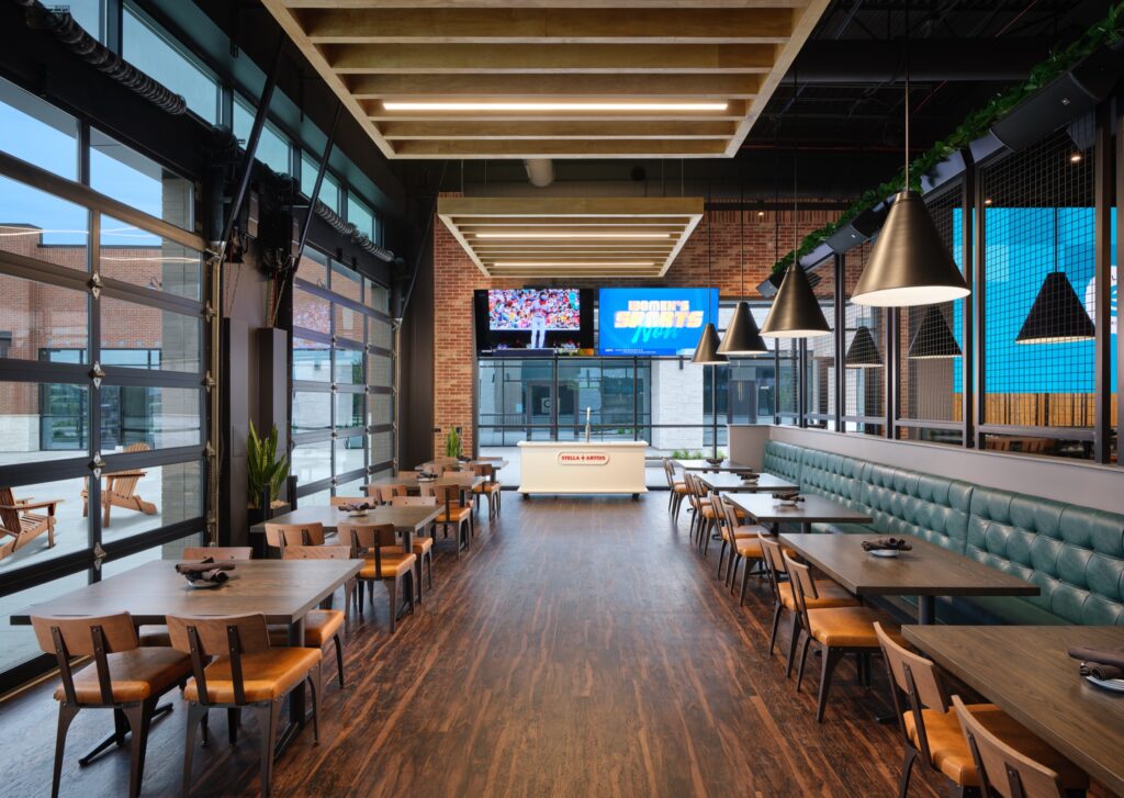 Dining room with garage-door windows and TVs at Simple EJ's