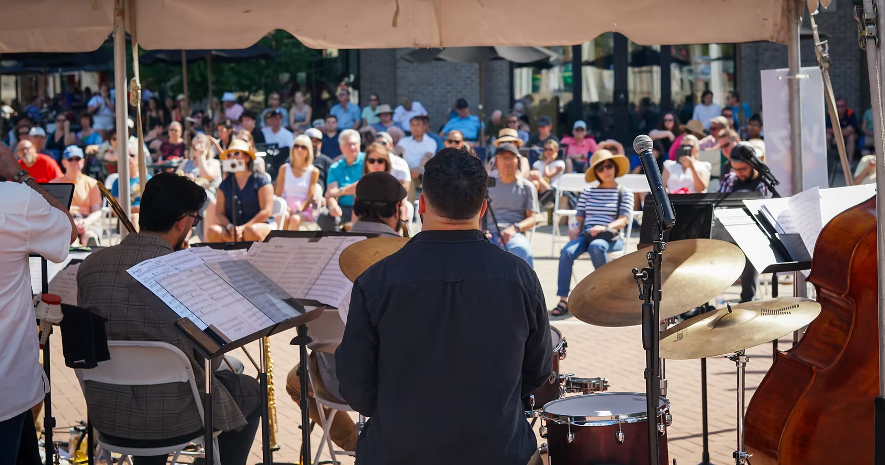 An outdoor jazz band playing to a crowd on the plaza in downtown St. Charles, Illinois, near Simple EJ's Kitchen and Tap at Fox Haven Square, one of many things to do in St. Charles, Illinois this month